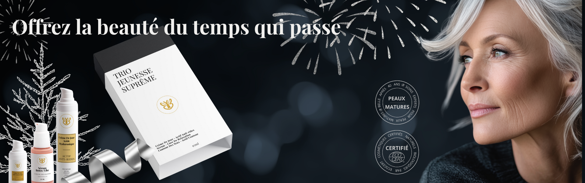 Femme élégante de 50 ans tenant le Coffret Trio Suprême Jeunesse Belle après 40 ans, dans une ambiance de Noël lumineuse et chaleureuse.
